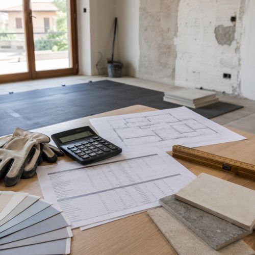 Pianificazione dei costi di ristrutturazione casa con computo metrico, campioni di materiali e ambiente domestico in fase di rinnovo. Tavolo con computo metrico, calcolatrice e campioni di pavimenti in un appartamento italiano in ristrutturazione