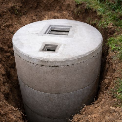 Immagine di una vasca Imhoff in cemento installata in uno scavo nel terreno, utile per illustrare costi e caratteristiche di una fossa biologica a norma.